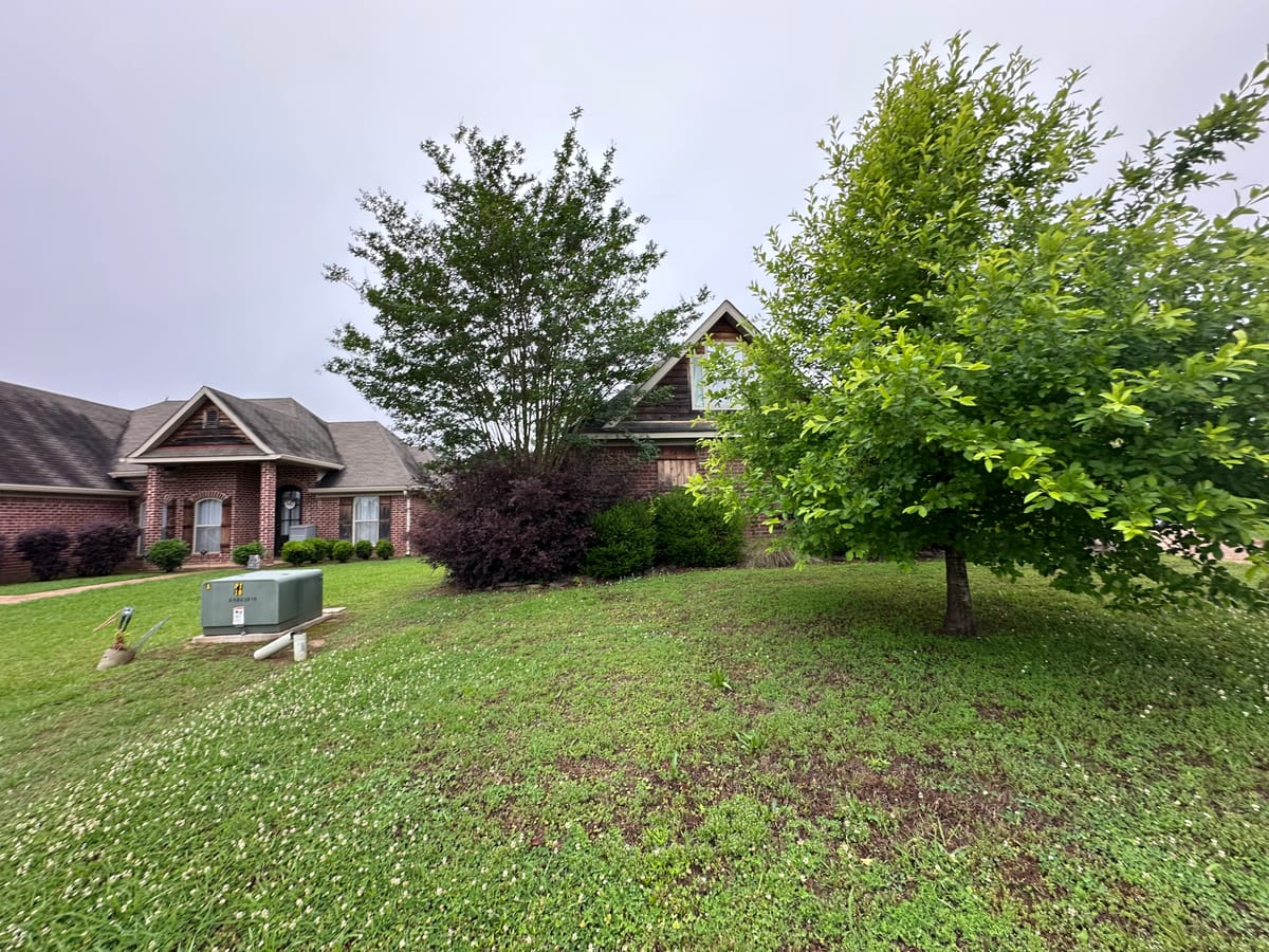 Overgrown landscape beds along a house